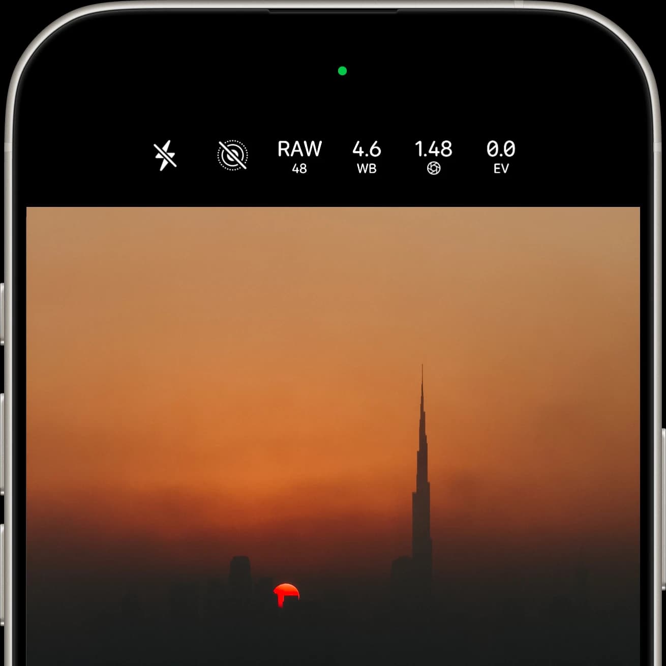 iPhone camera app shooting RAW at 48MP, white balance 4.6, ƒ/1.48 and 0.0 EV, framing the Burj Khalifa against an orange sunset